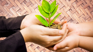 Une image de 2 mains se donnant une petite plante verte qui poussent dans de pièces d'argent, illustrant l'extrait de la page 