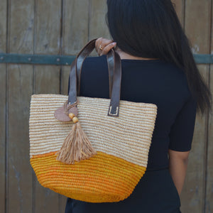 Sac jaune et naturel en raphia naturel, chic pour la ville et pratique pour la plage. Son anse en cuire de zébu et ses petits détails apportent tout le charme et l'unicité de ce sac. 