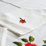 Nappe blanche avec des roses rouges brodées à la main par les artisans de Madagascar. Serviette de table lavable.