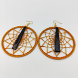 Boucle d'oreille type créole "Raffimendrika", bijoux artisanal, en corne de zébu foncée et raphia orange, vue de profil